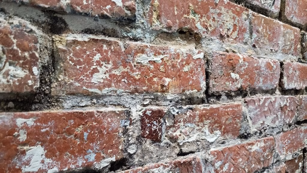 Brick restoration on a residential masonry wall, showing repaired brickwork and renewed mortar joints for a clean, durable finish