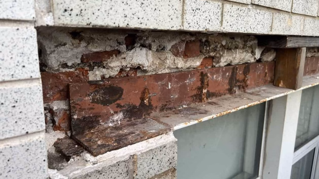 Brick masonry wall with a window opening and structural lintel supporting the brickwork above the window