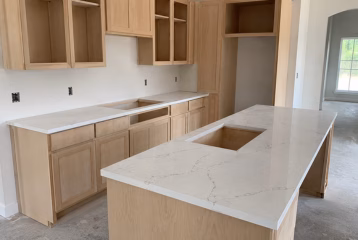 Countertops installed on unfinished kitchen cabinetry during construction