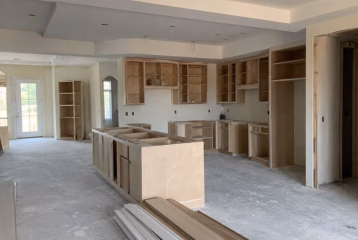 Unfinished custom cabinetry installation inside a naturally lit construction site