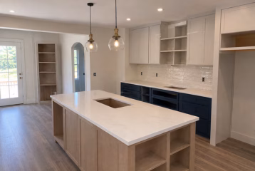 Kitchen lighting installation with recessed lights and pendant fixtures in a construction-stage kitchen