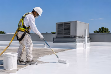 Professional worker applying waterproof coating to a commercial TPO roof.